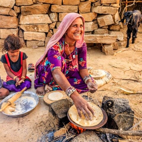 A woman and two children embark on a culinary adventure, following their favorite recipe guide as they cook together in the kitchen.