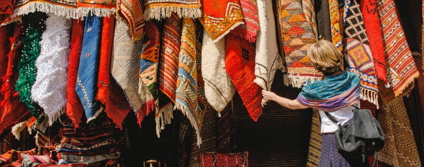 A woman shopping for carpets rugs in Marrakech.