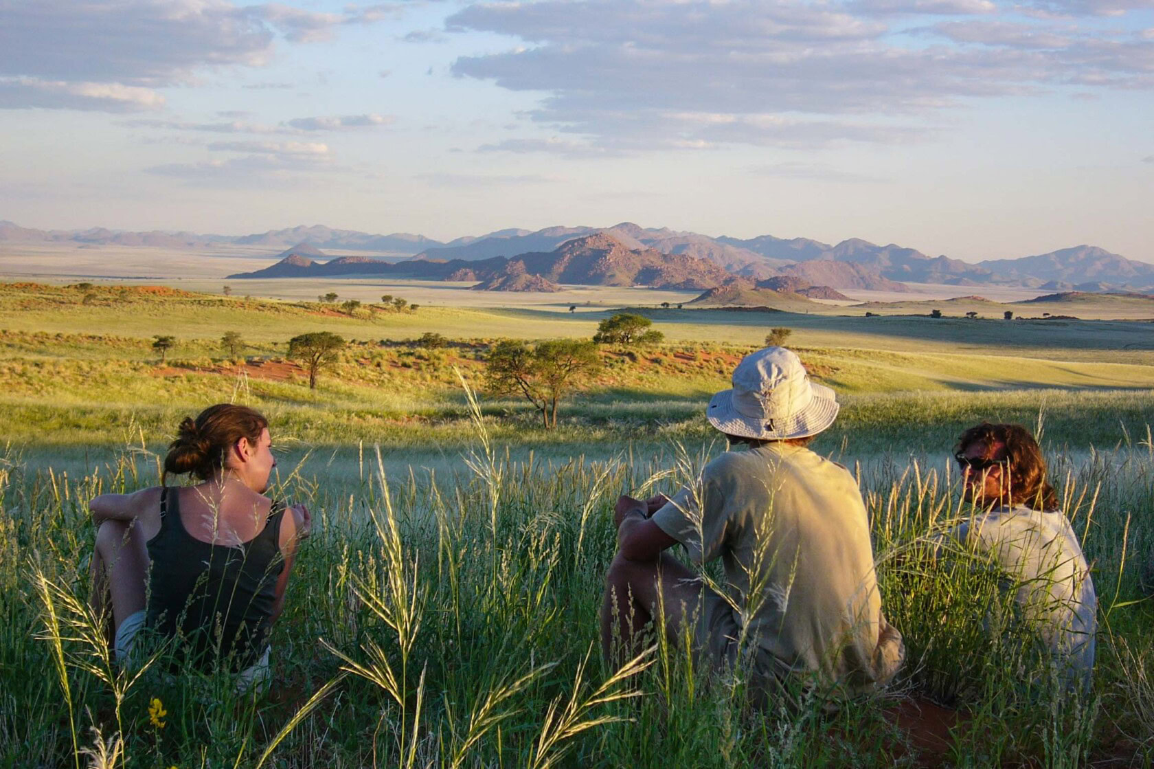 People sitting on a hill on a trail in Namibia.