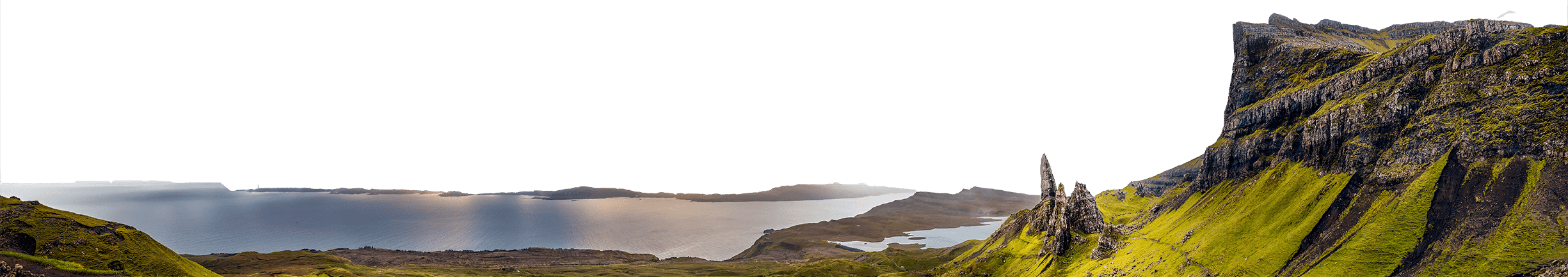 Panoramic view of a rugged coastline with high cliffs, green hills, and a calm body of water under a partly cloudy sky—a travel destination that beckons to those seeking breathtaking places.